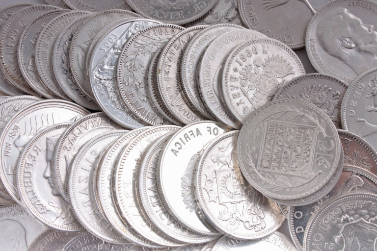 visual of many silver coins on a table.